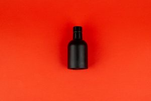 Armaf Club De Nuit Intense Man - elegancka czarna flasza perfum na czerwonym tle
