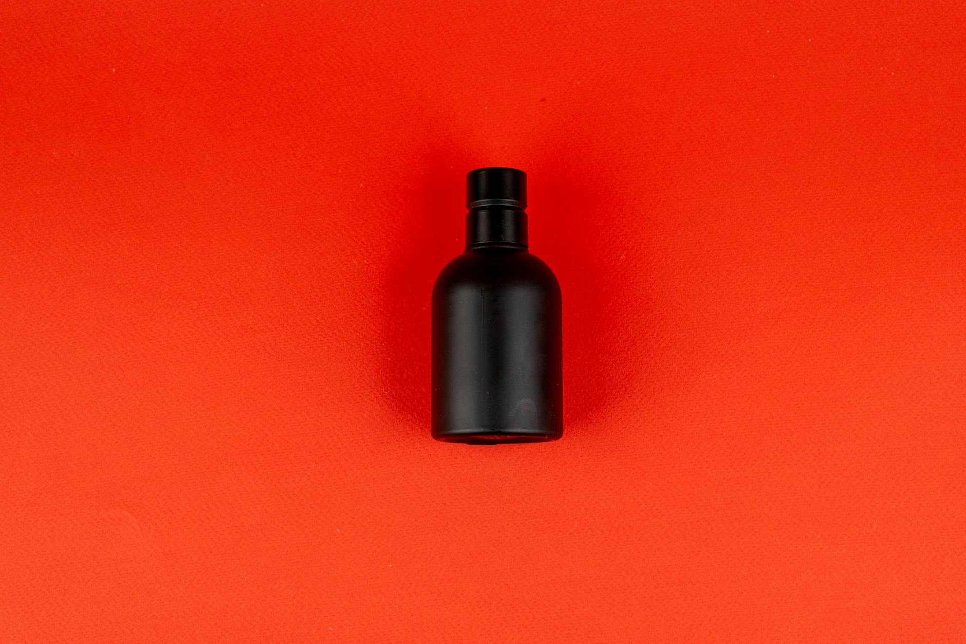 Armaf Club De Nuit Intense Man - elegancka czarna flasza perfum na czerwonym tle